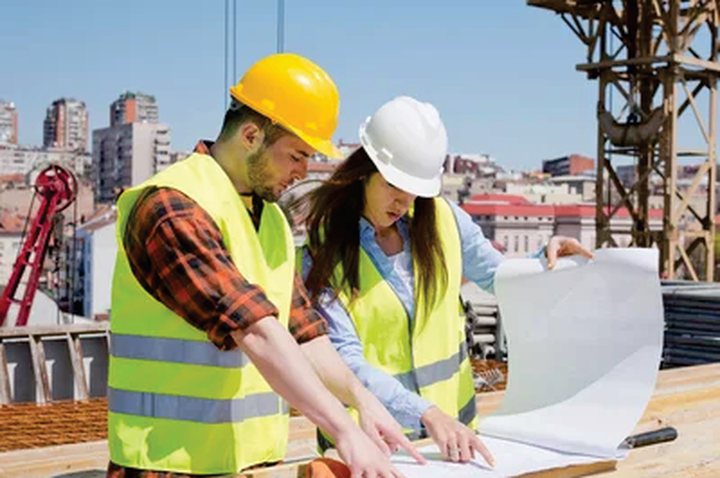 Personal con casco de seguridad trabajando en obra